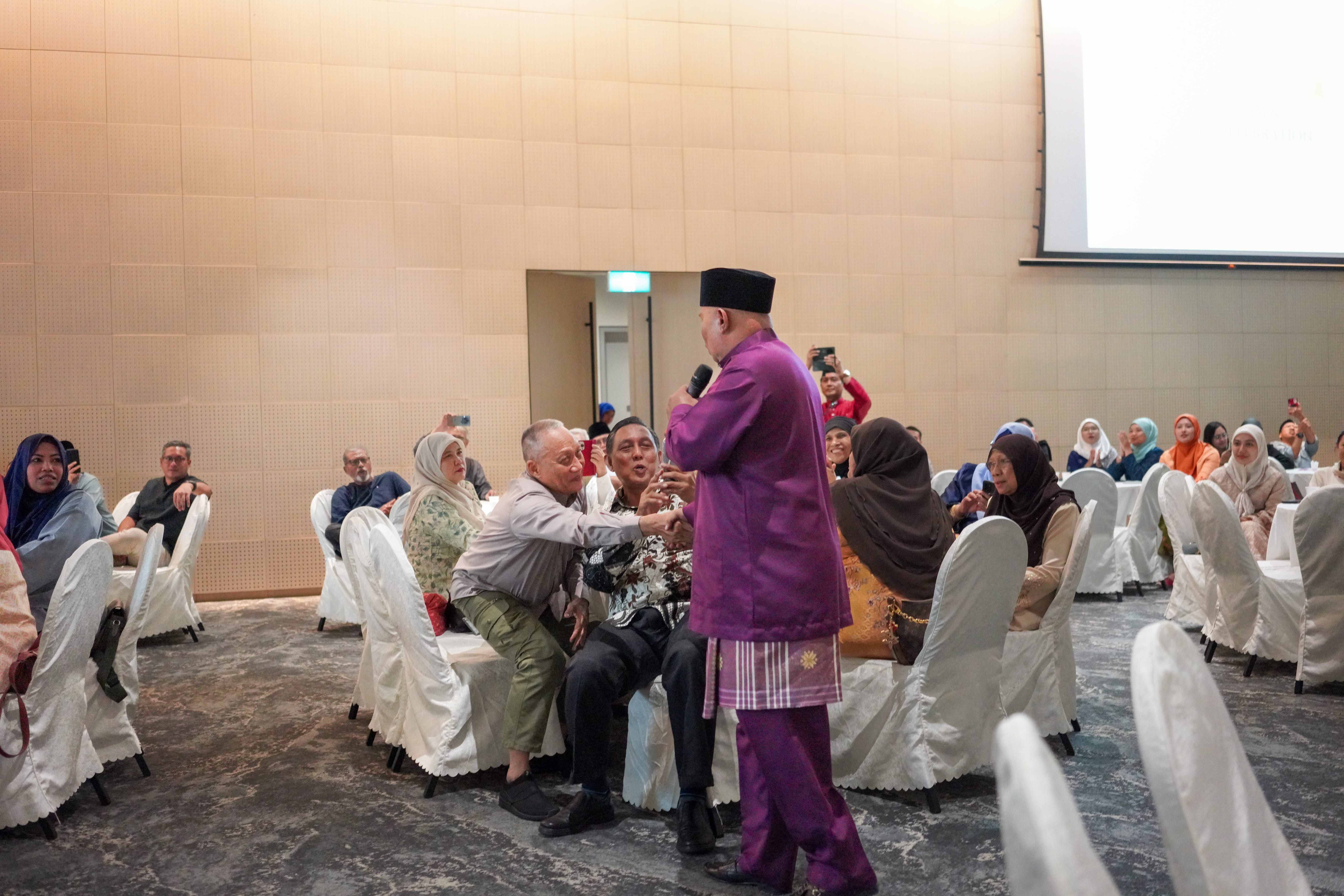 A participant engaging with guests during an interactive entertainment activity in the function hall.